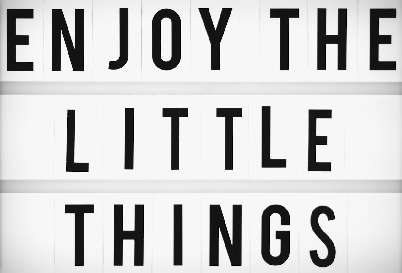 services-01 Minimalist design of the inspirational quote 'Enjoy The Little Things' displayed on a lightbox.