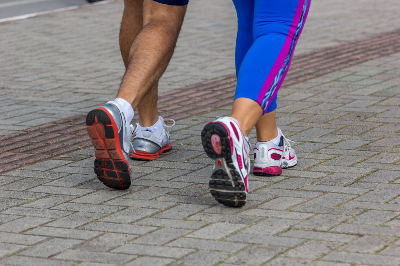 hero-img-01 People jogging on a city street, giving a close-up of their sportswear shoes. Urban fitness scene.
