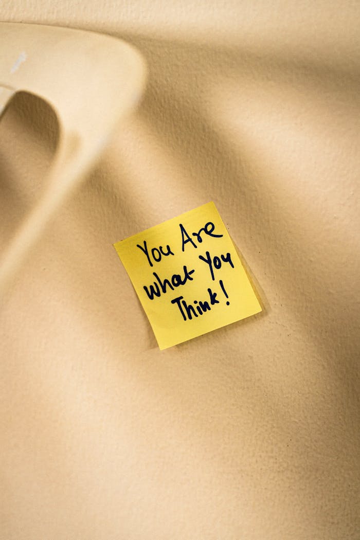 gallery-4 Yellow sticky note with motivational message on beige surface.