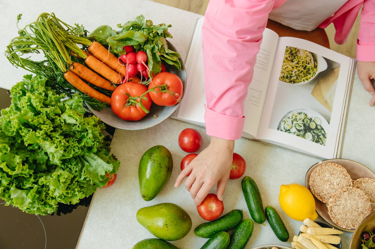 why-choose-us Top view of fresh vegetables and hands arranging them with a recipe book, promoting healthy eating.